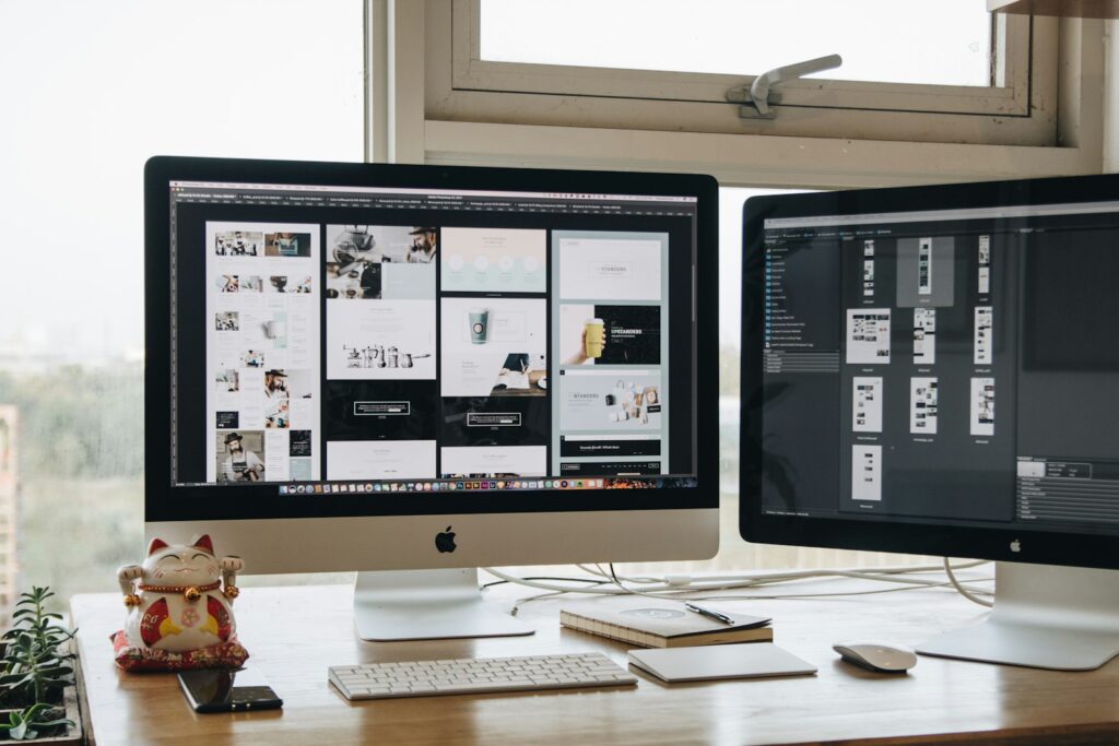 Webontwerper aan een bureau met een website-ontwerp op een groot scherm