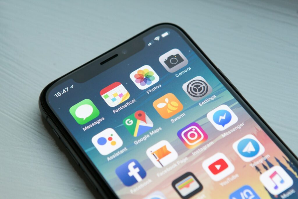 Smartphone met een chatapp open op een bureau naast een notitieboek
