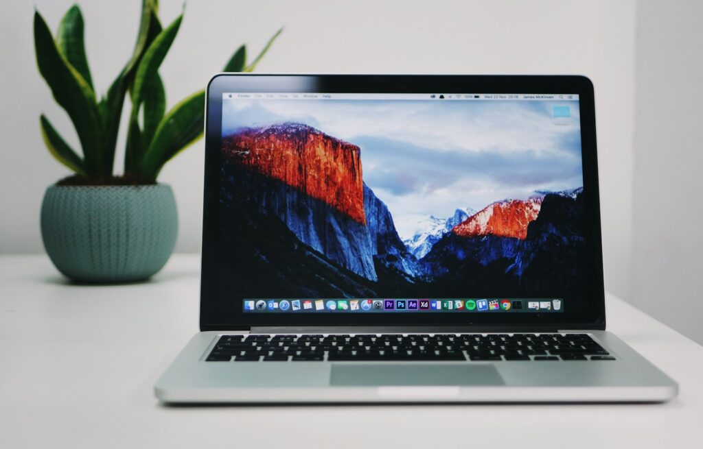 Laptop met een kantoorprogramma open op een bureau met een notitieblok ernaast
