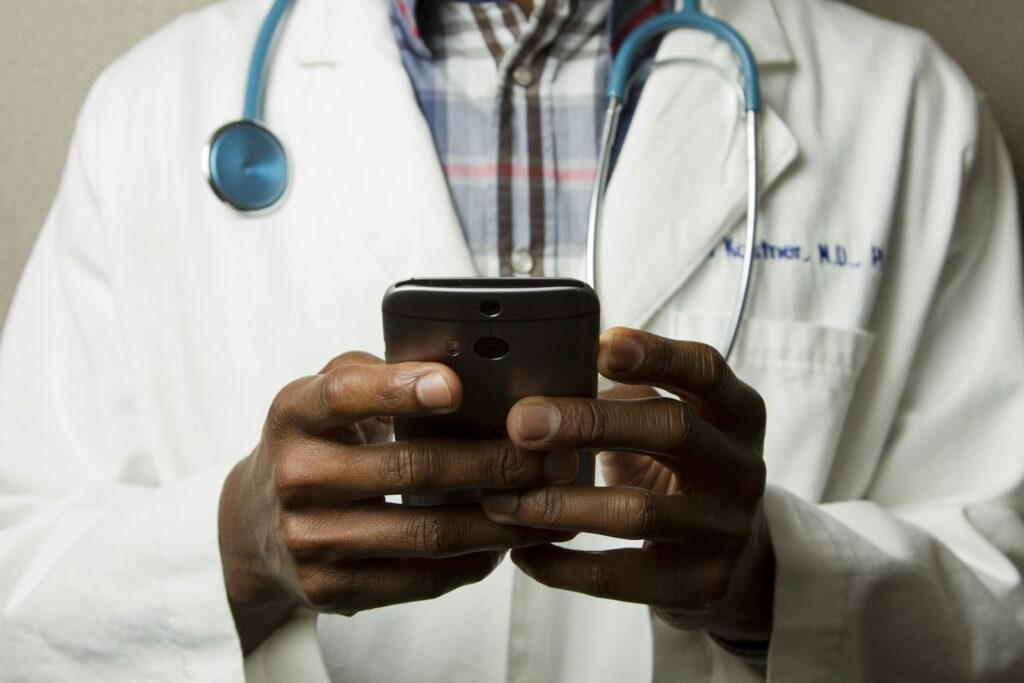 Persoon zoekt op een smartphone naar klachten terwijl hij op de bank zit