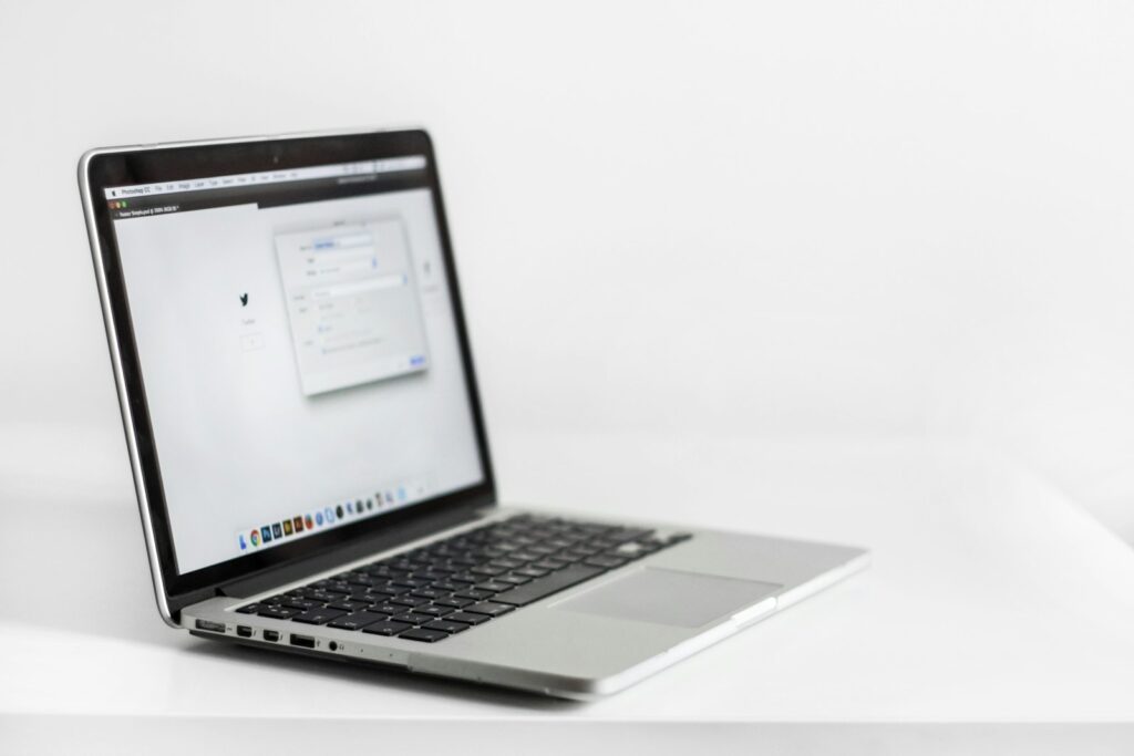 Laptop met een geopend pdf-document naast een uitgeprint contract op een bureau