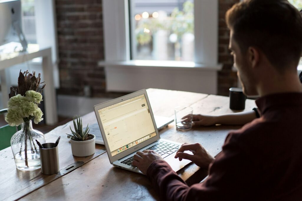 Medewerker aan een bureau met een chatvenster op een laptop
