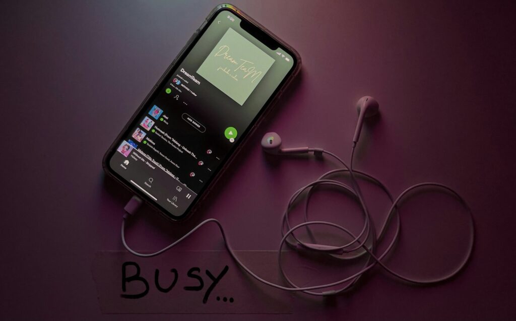 Telefoon met een muziekapp naast een koptelefoon