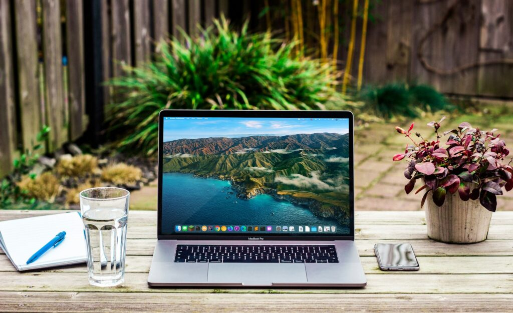 Laptop met een website voor vakantiewoningen op een tafel naast een koffiekop