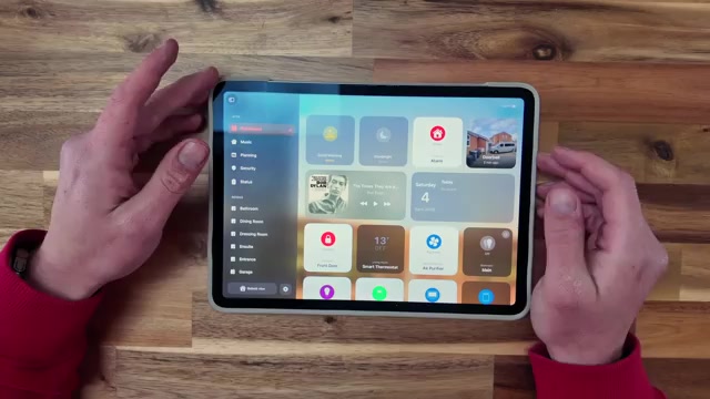 Handen houden een iPad vast met een dashboard van de Woning-app voor het slimme huis