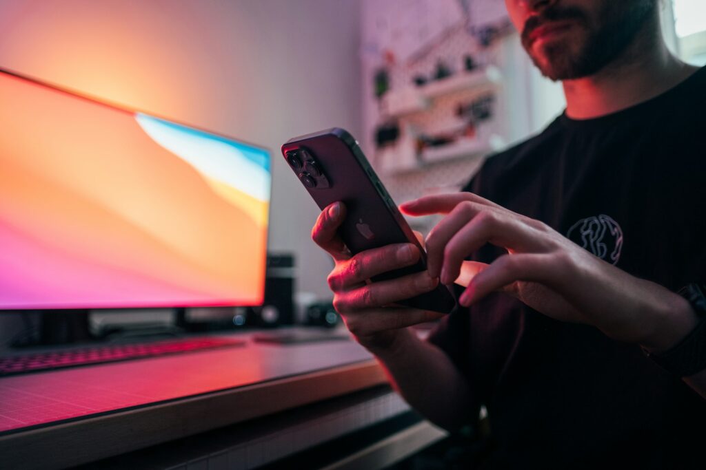 Smartphone met een bankapp op een bureau naast een laptop en een notitieboek