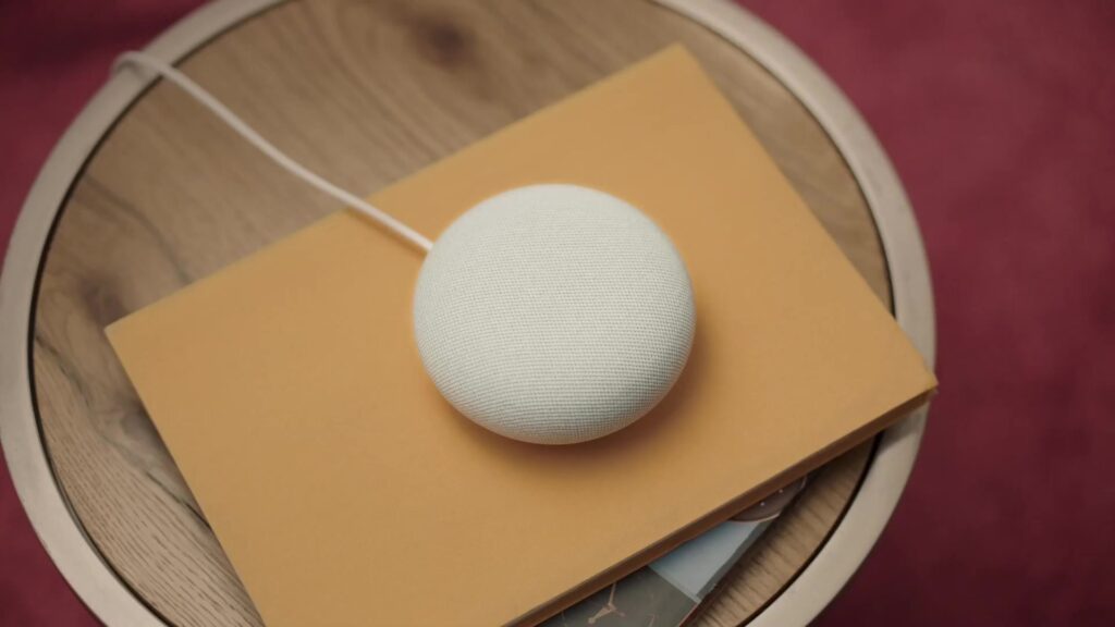 Google Nest Mini-speaker op een houten bijzettafel