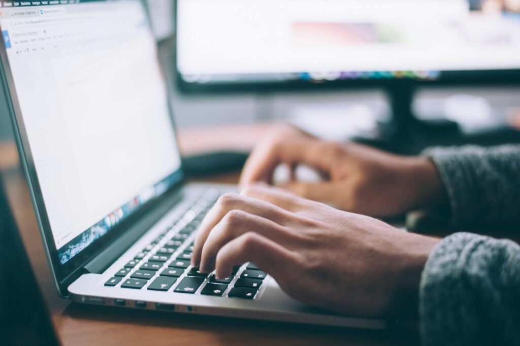 Laptop met een inlogscherm en een telefoon met een verificatiecode op een bureau