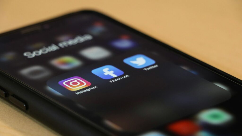 Hand met een smartphone waarop een sociale-media-app geopend is