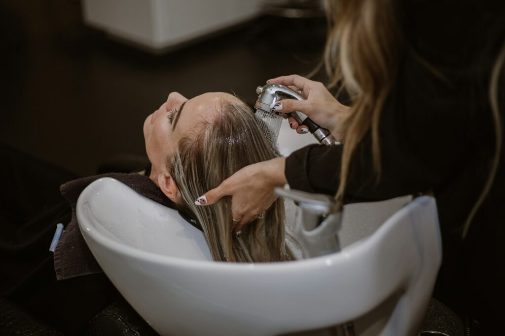 Kapper bespreekt met een klant een foto op de telefoon in een kapsalon