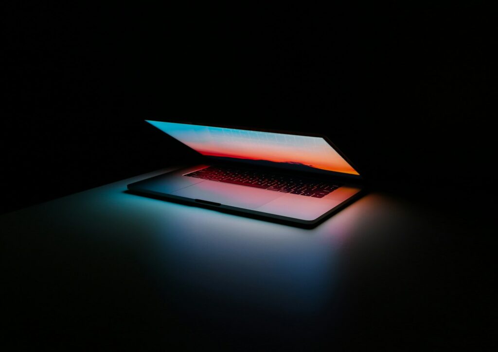 Laptop met een presentatie op het scherm naast een notitieboek op een bureau