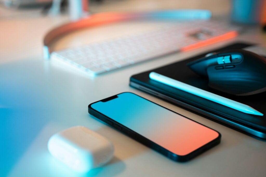 Telefoon met een spraakassistent op een bureau naast een koptelefoon en notitieboek